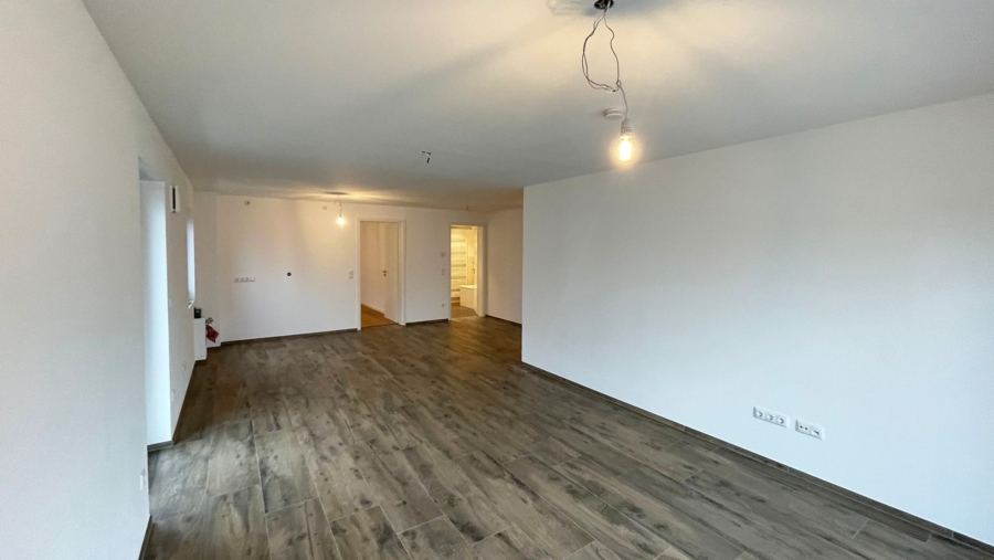 Moderne 3-Zimmer-Wohnung mit großem Westbalkon, 2 TG-Stellplätze & großem Tageslichtbad - Wohnzimmer Ansicht 3